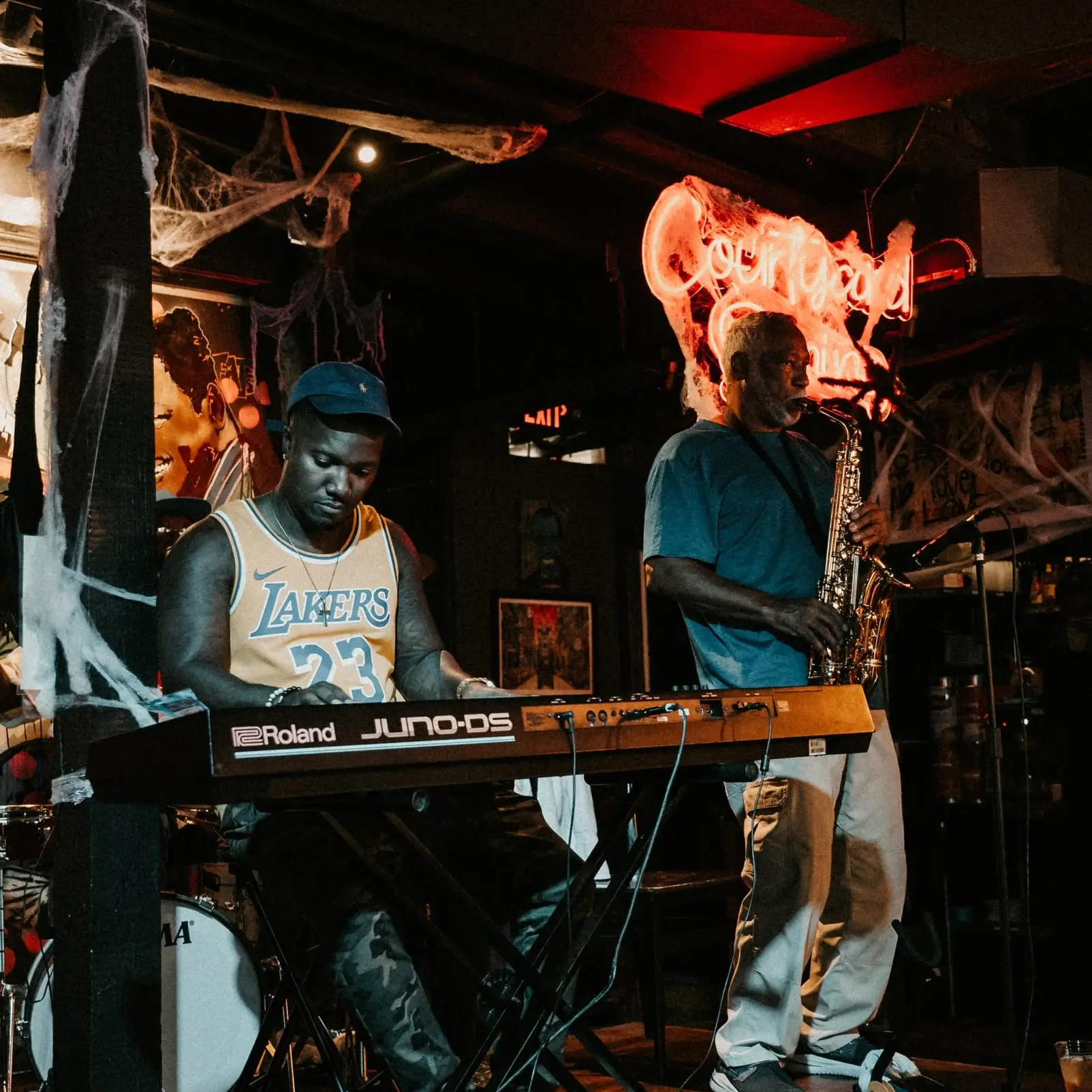 A keyboardist and a saxophonist play together on the stage