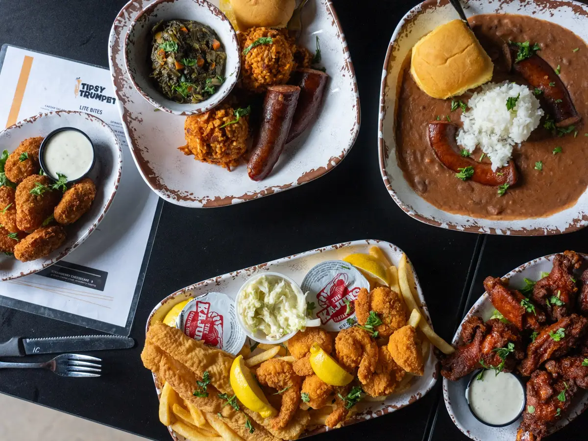 Tipsy Trumpet food from above: jalapeño poppers, red beans and rice, jambalaya with smoked sausage and greens, a fried seafood platter and wings